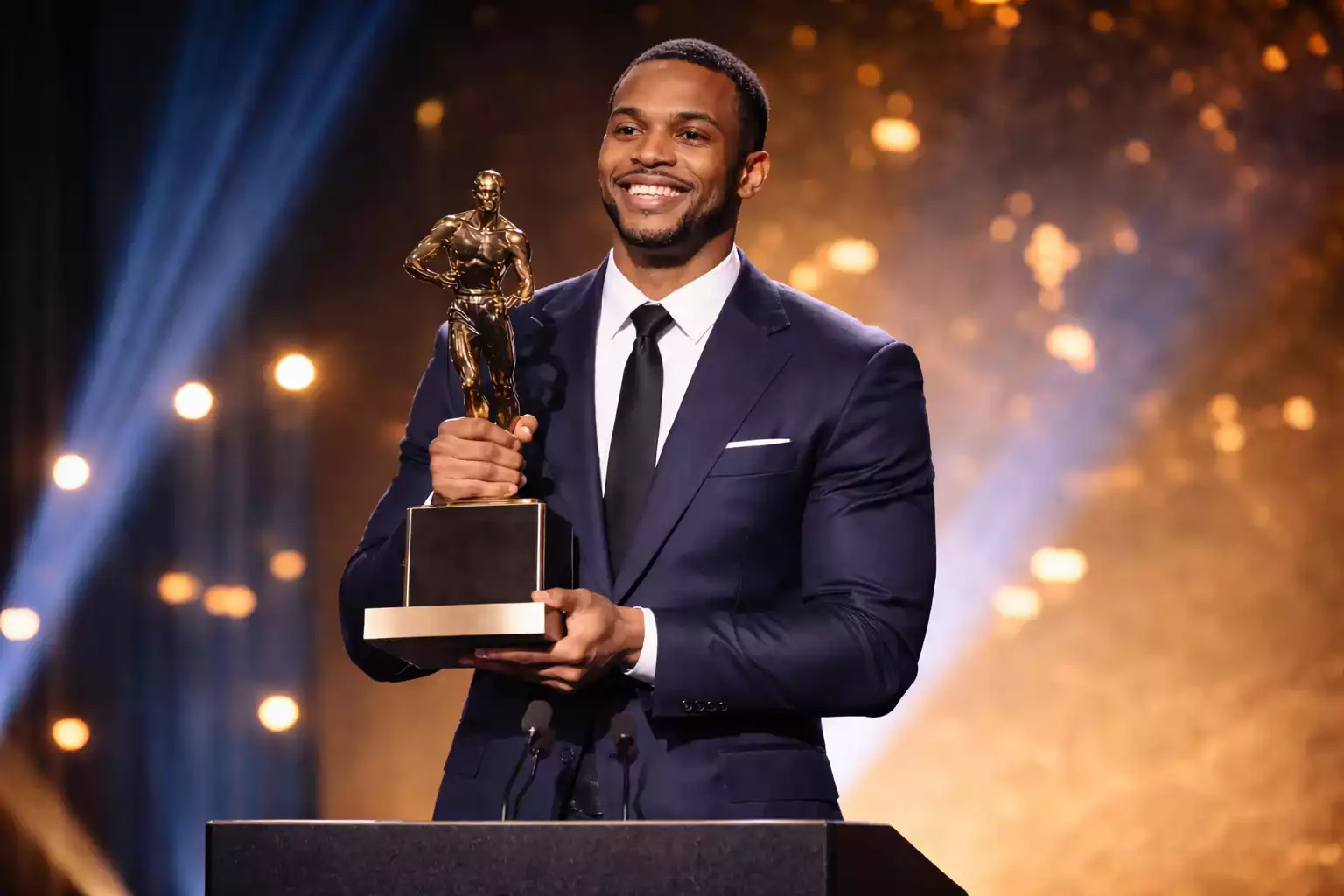 Basketball player holding MVP trophy at awards ceremony